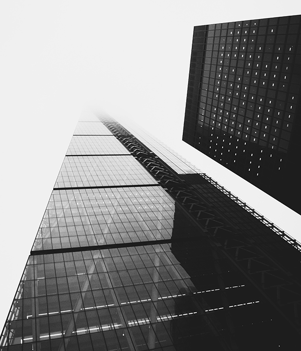 Black and white photo of modern skyscrapers from below.